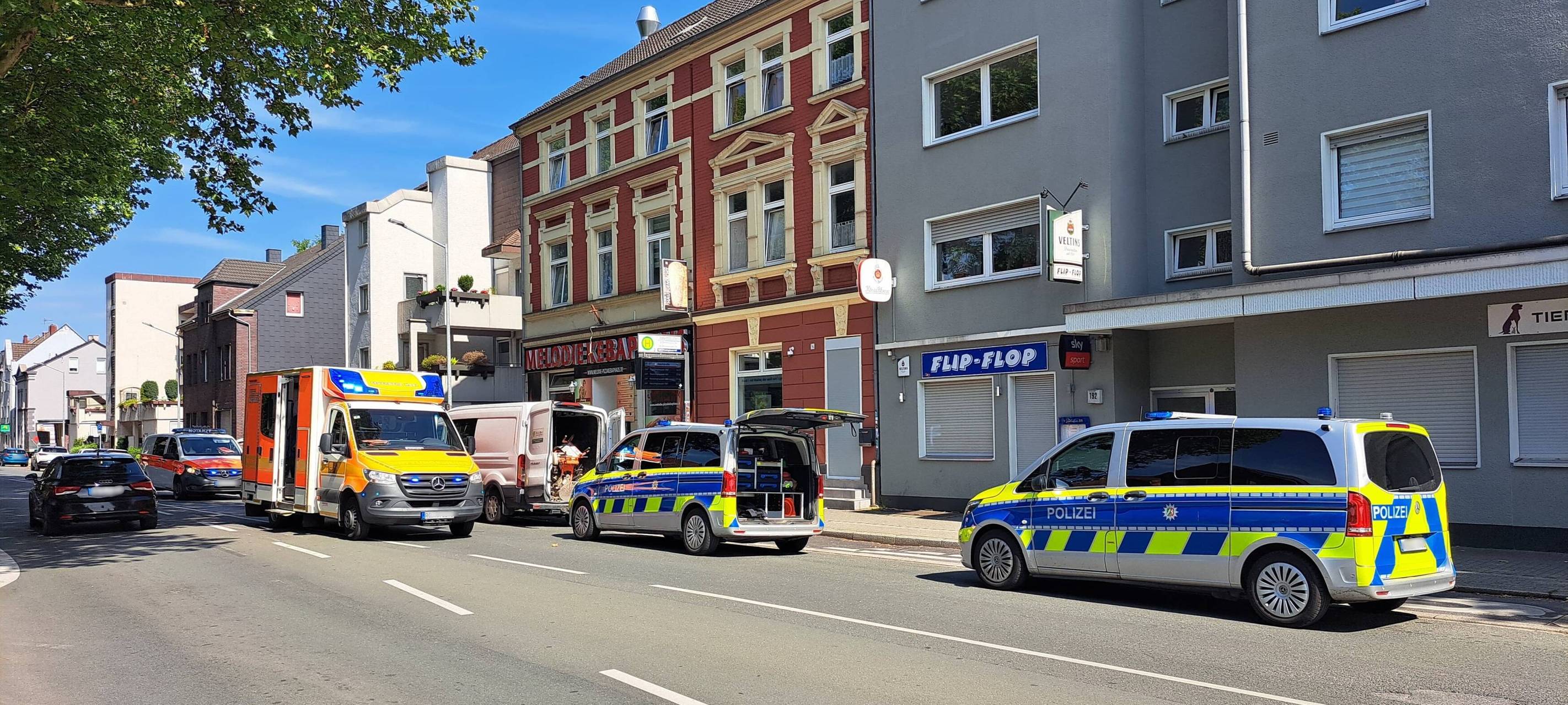 Die Polizei hindert weitere Männer an der Flucht mit einem weißen Transporter.